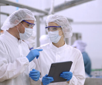 Product researcher or quality control engineer or production line worker in white sterile uniforms prevent contamination of food and drink product industry or cosmetic manufacturing plants or processed food or canned food, discuss about product at factory